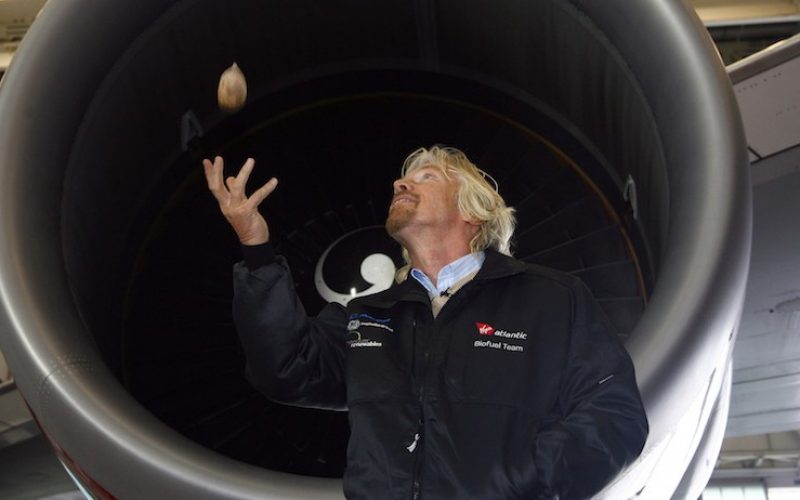 Virgin Group chairman Richard Branson throws a babassu nut in front of a Virgin Atlantic Boeing 747 aircraft, before the world's first commercial biofuel flight to Amsterdam from Heathrow Airport, in London February 24, 2008. Nuts picked from Amazon rainforests helped fuel the world's first commercial airliner flight powered by renewable energy on Sunday.     REUTERS/Luke MacGregor   (BRITAIN) - RTR1XI0O